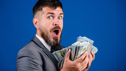 Cash transaction business. Man happy winner rich hold pile of dollar banknotes blue background. Easy cash loans. Businessman got cash money. Win lottery concept. Get cash easy and quickly