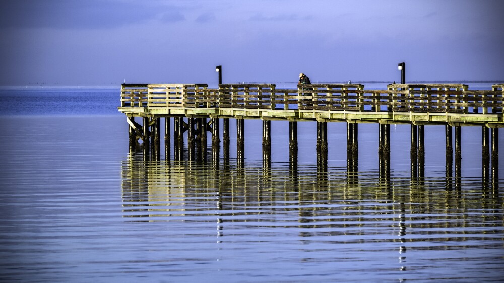 A fisherman on the Charlotte Harbor fishing pier in the morning.