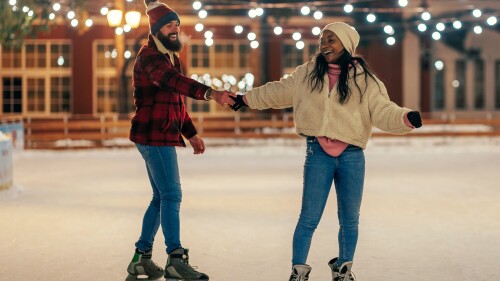 Couple on winter holiday ice skating.